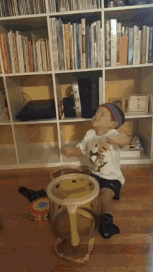 a little boy is playing with a toy in front of a bookshelf that has a book called the princess castle on it