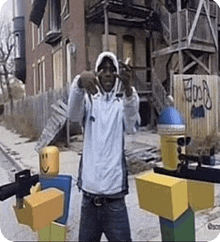 a man in a white hoodie is standing in front of a building next to a lego man .