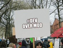 a sign that says #dev over mod in a crowd