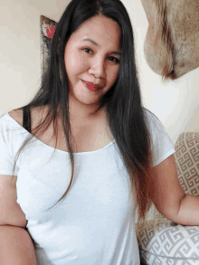 a woman in a white shirt is sitting on a patterned couch