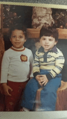 two young boys are posing for a picture and one has a lion on his shirt