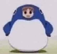 a white penguin with a blue hat on its head is standing on a grassy field .