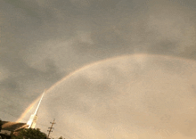 a church steeple with a rainbow in the sky