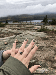 a close up of a woman 's hand with a ring on her finger