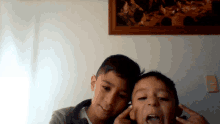 two young boys are posing for a picture in front of a framed picture