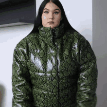 a woman wearing a green snakeskin puffer jacket .