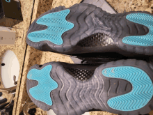 the bottom of a pair of black shoes with blue soles