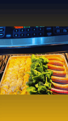 a tray of broccoli and sausages is being cooked in an oven with the temperature set to 400 degrees