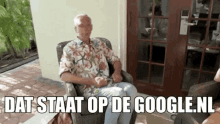 a man is sitting in a chair with the words dat staat op de google.nl written below him