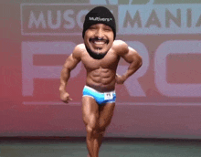 a bodybuilder wearing a black multiverse hat and blue underwear