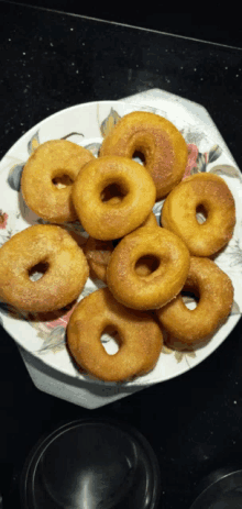 a white plate topped with a bunch of donuts with holes in them