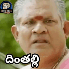 a man with a red flower on his forehead is making a funny face in telugu .