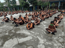 a group of children wearing face masks sit on the ground