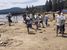 a group of people on a beach with one man wearing a t-shirt that says ' mickey mouse ' on it