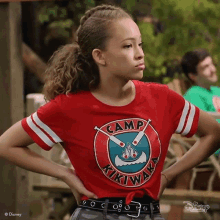 a girl wearing a red t-shirt that says camp kiki way on it