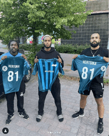 three men holding up jerseys with hertsika 81 on them