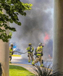 a group of firefighters are fighting a fire in a parking lot