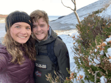 a man wearing a napapijri jacket stands next to a woman in the snow