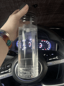 a person holding a bottle of water in a car