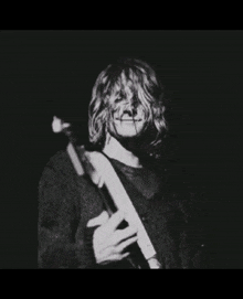 a black and white photo of a man holding a guitar with a purple heart behind him and the words love below him