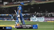 a cricket player named rohit sharma is walking on the field with a bat