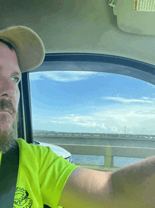 a man driving a car with a warning label on the visor that says " warning "