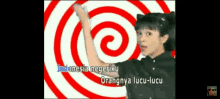 a woman singing indonesia negeriku orangnya lucu-lucu in front of a red and white spiral