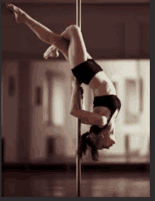 a pole dancer is doing a handstand on a pole