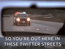 a police car is driving down a highway with the words " so you 're out here in these twitter streets " below it