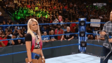 a woman standing in a wrestling ring with a sign that says " i love you "