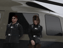 a man and a woman stand in front of a helicopter with the letter b on the side