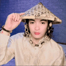 a young man wearing a conical hat and a watch