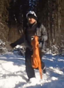 a person is walking through the snow carrying an orange scarf