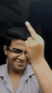 a man wearing glasses is making a middle finger gesture