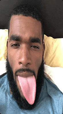 a man with a beard sticks out his tongue