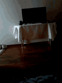 a white cloth is laying on a wooden floor in a dark room