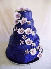 a purple wedding cake with purple flowers on top of it is on a table .