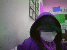 a person wearing a mask and a purple hoodie stands in front of a bulletin board with drawings on it