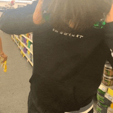 a person is standing in a store with their arms outstretched and a black shirt on .