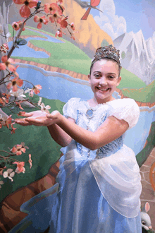 a girl in a cinderella costume holds a flower in her hands