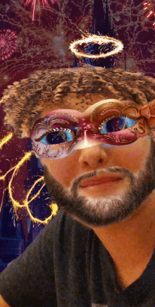 a man with a beard is wearing a mask with fireworks in the background