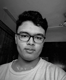 a black and white photo of a young man wearing glasses with the date november 2nd 2024