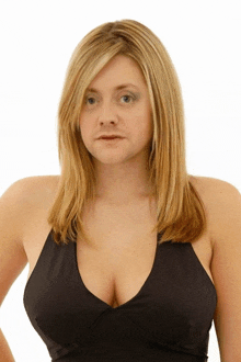 a woman with blonde hair is wearing a black tank top with a plunging neckline