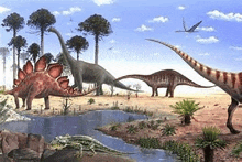 a group of dinosaurs are standing next to each other in a field near a body of water .