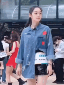 a woman wearing a denim shirt that says ' t.v. ' on it