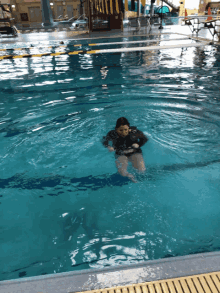 a woman is swimming in a large pool