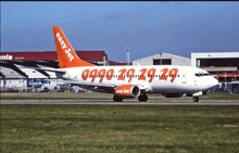 a white and orange easy jet plane is sitting on the runway