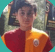 a young boy wearing a red and orange shirt with a logo on it