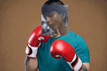 a man wearing red boxing gloves has a picture of a man behind him