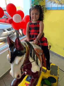 a little girl is riding a rocking horse